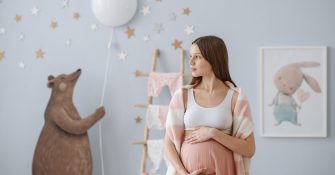 picture of pregnant woman standing in a baby's room