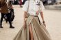 woman wearing beige maxi skirt with black belt, white t-shirt and beige bag