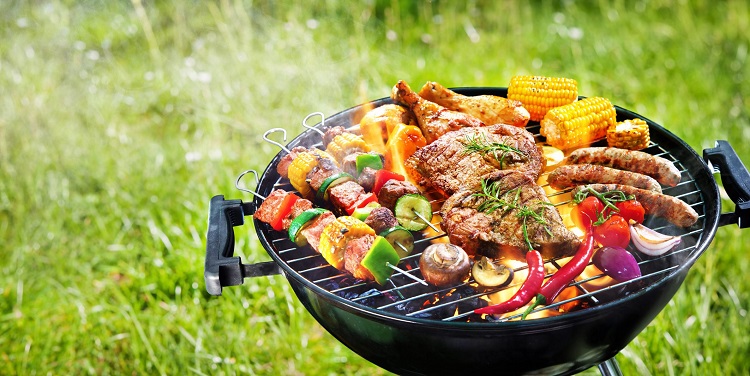 barbeque smoker with meat and vegetables on it