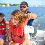 kids wearing life jackets on the boat